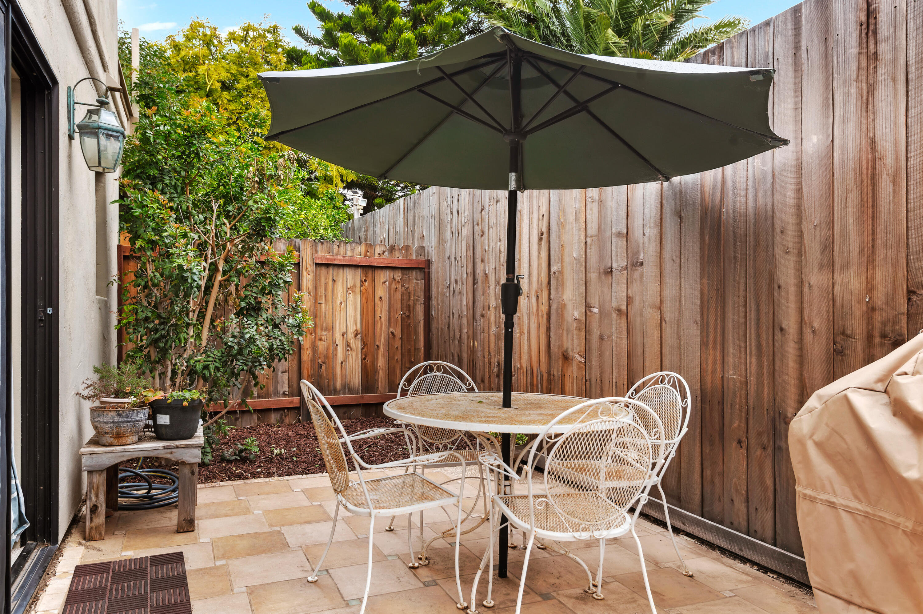 4344 Modoc Road, Unit 15 Santa Barbara, CA 93110 - Photo 16 of 19 a patio with a table and chairs under an umbrella