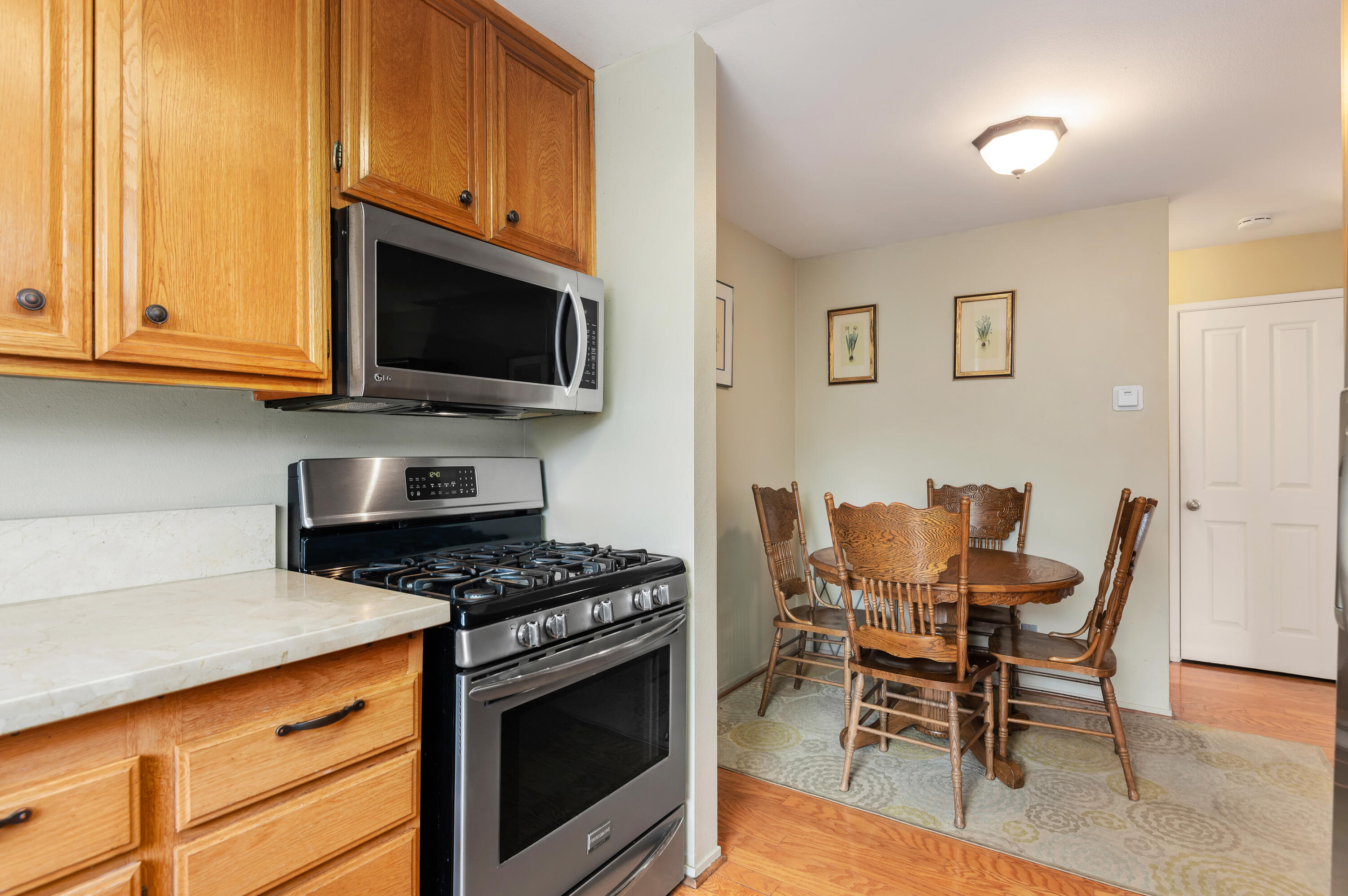 4344 Modoc Road, Unit 15 Santa Barbara, CA 93110 - Photo 7 of 19 a kitchen with stainless steel appliances kitchen island granite countertop a stove top oven a sink a dining table and chairs with wooden floor