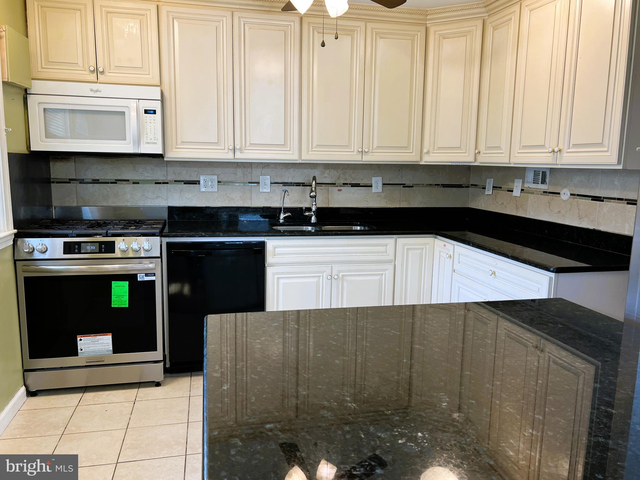 3705 Bancroft Road Baltimore, MD 21215 - Photo 6 of 50 a kitchen with stainless steel appliances granite countertop a stove a sink and a microwave