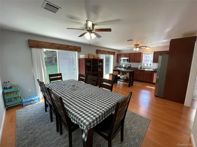 a dining room with furniture a rug a chandelier and wooden floor
