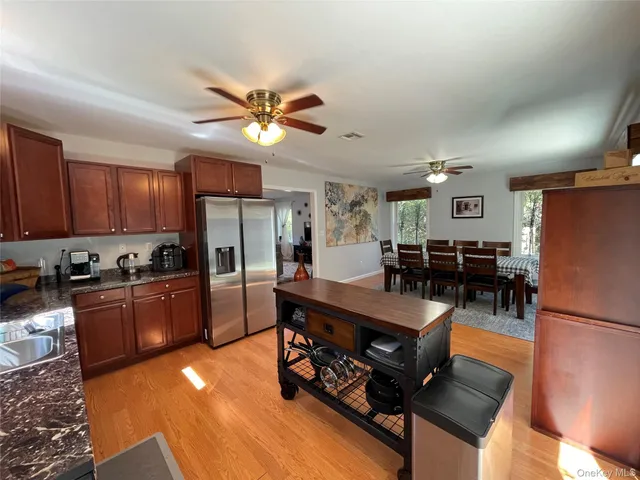 a large kitchen with stainless steel appliances granite countertop a stove refrigerator and cabinets