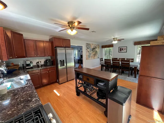 a kitchen with stainless steel appliances granite countertop a refrigerator a stove top oven a sink dishwasher and white cabinets