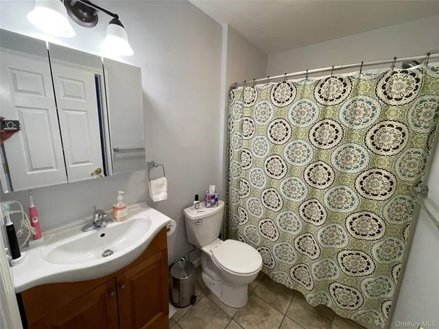 a bathroom with a toilet sink shower and mirror