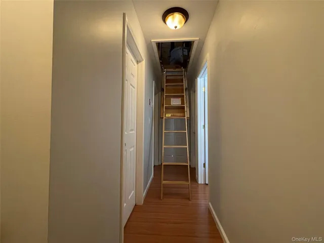 a view of a hallway with wooden floor and entryway