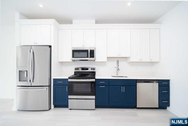 12-01 River Road, Unit 205 Fair Lawn, NJ 07410 - Photo 4 of 13 a kitchen with stainless steel appliances a refrigerator stove microwave and sink