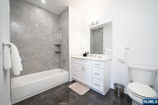 12-01 River Road, Unit 205 Fair Lawn, NJ 07410 - Photo 9 of 13 a bathroom with a toilet a sink a mirror a bathtub and vanity