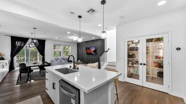 a kitchen with stainless steel appliances granite countertop a sink a stove and a wooden floor