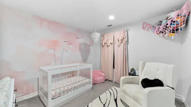 a living room with furniture and a baby crib