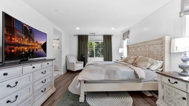 a bedroom with a large bed and a flat screen tv on the dresser