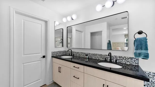 a bathroom with a granite countertop sink and a mirror