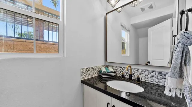a bathroom with a granite countertop sink and a mirror