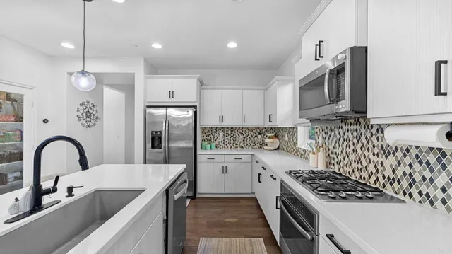a kitchen with granite countertop a sink stainless steel appliances and cabinets