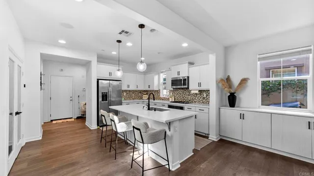 a kitchen with white cabinets and refrigerator