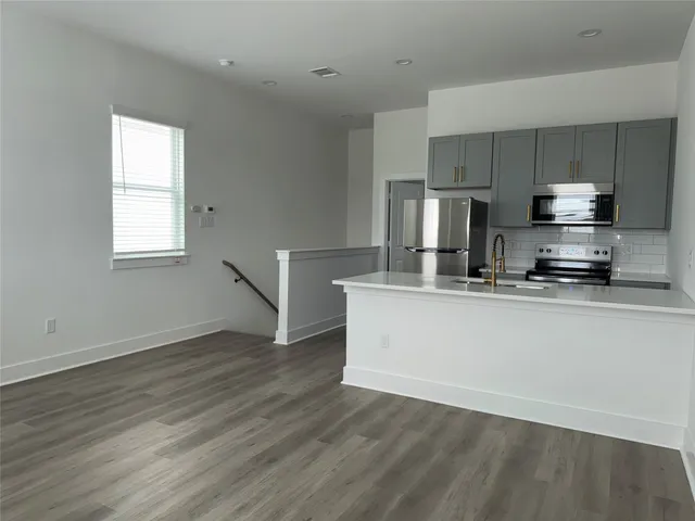 a view of kitchen with wooden floor and electronic appliances