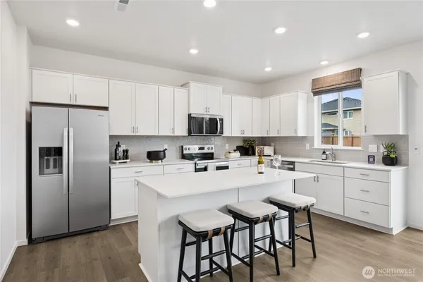 a kitchen with white cabinets and stainless steel appliances