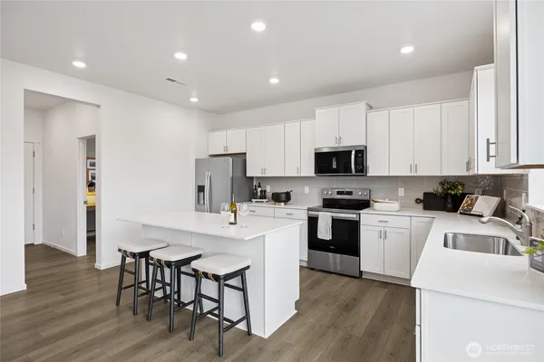 a kitchen with white cabinets stainless steel appliances and sink