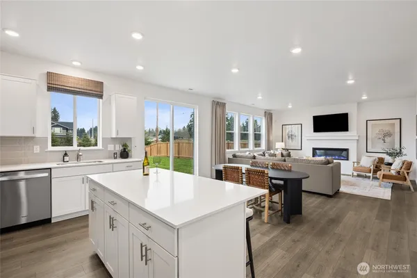 a large kitchen with kitchen island a sink table and chairs