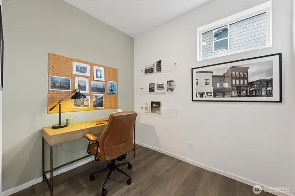 a view of a workspace with furniture and a window