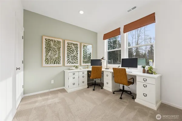 a view of a workspace with furniture and a window