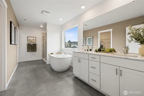 a spacious bathroom with a double vanity sink a mirror and a bathtub
