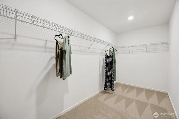 a view of walk in closet with clothes