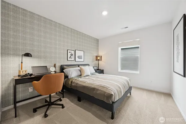 a bedroom with a bed a table and chair