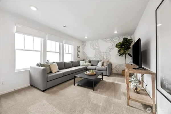 a living room with furniture a flat screen tv and a window