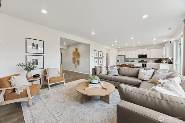 a living room with furniture and a view of kitchen