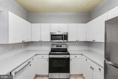 a kitchen with stainless steel appliances granite countertop a sink and a white cabinets