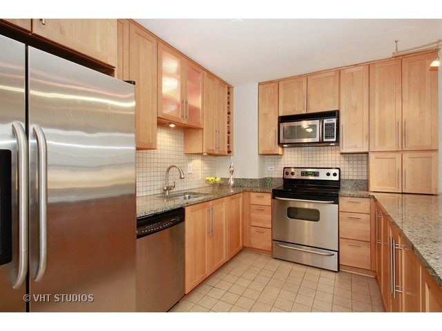33 East Cedar Street, Unit 5F Chicago, IL 60611 - Photo 2 of 11 a kitchen with kitchen island a counter top space cabinets and stainless steel appliances