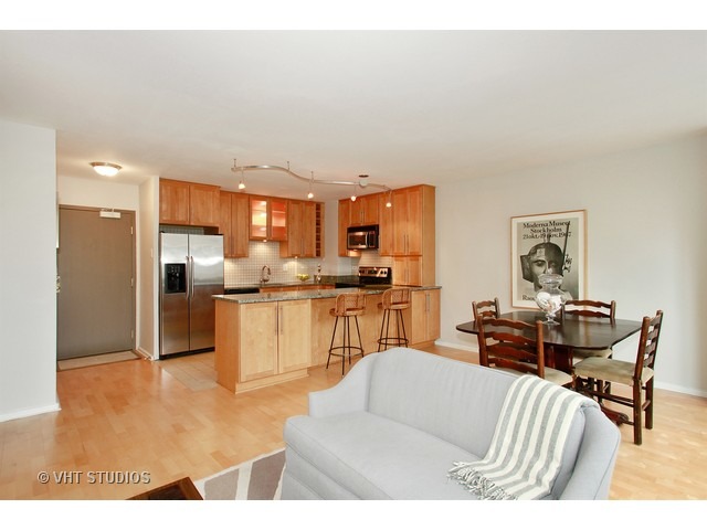33 East Cedar Street, Unit 5F Chicago, IL 60611 - Photo 5 of 11 a living room with furniture a kitchen view and a dining table