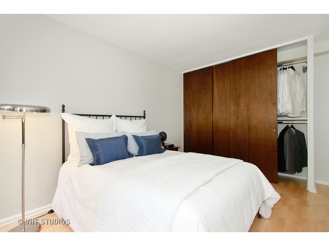 33 East Cedar Street, Unit 5F Chicago, IL 60611 - Photo 9 of 11 a bedroom with a bed and wooden floor