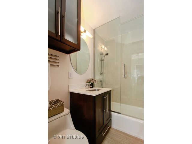 33 East Cedar Street, Unit 5F Chicago, IL 60611 - Photo 10 of 11 a bathroom with a sink a mirror and vanity