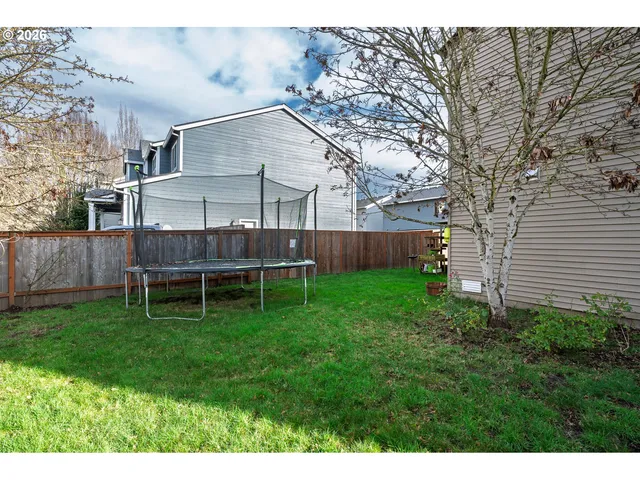a view of a chair and table in backyard of the house