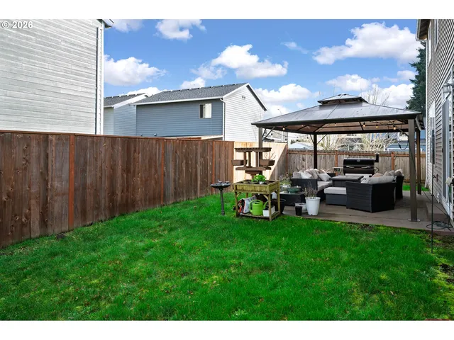 a view of a house with backyard and a sitting area
