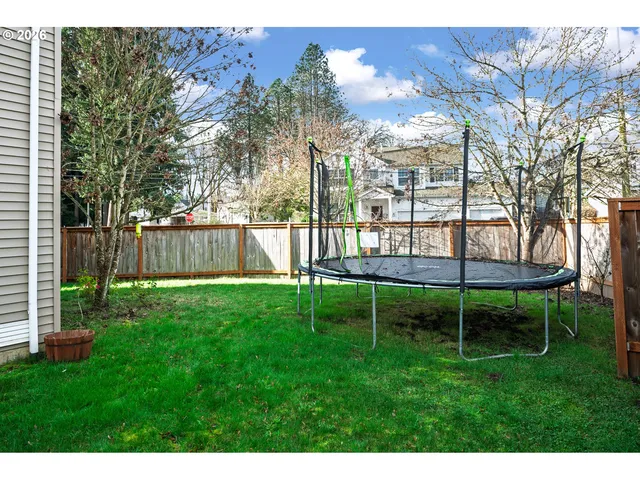a view of a backyard with table and chairs under an umbrella