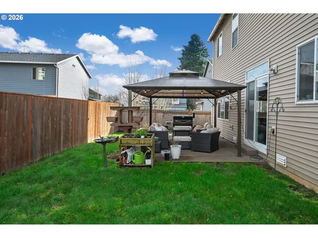 a view of a house with backyard and sitting area