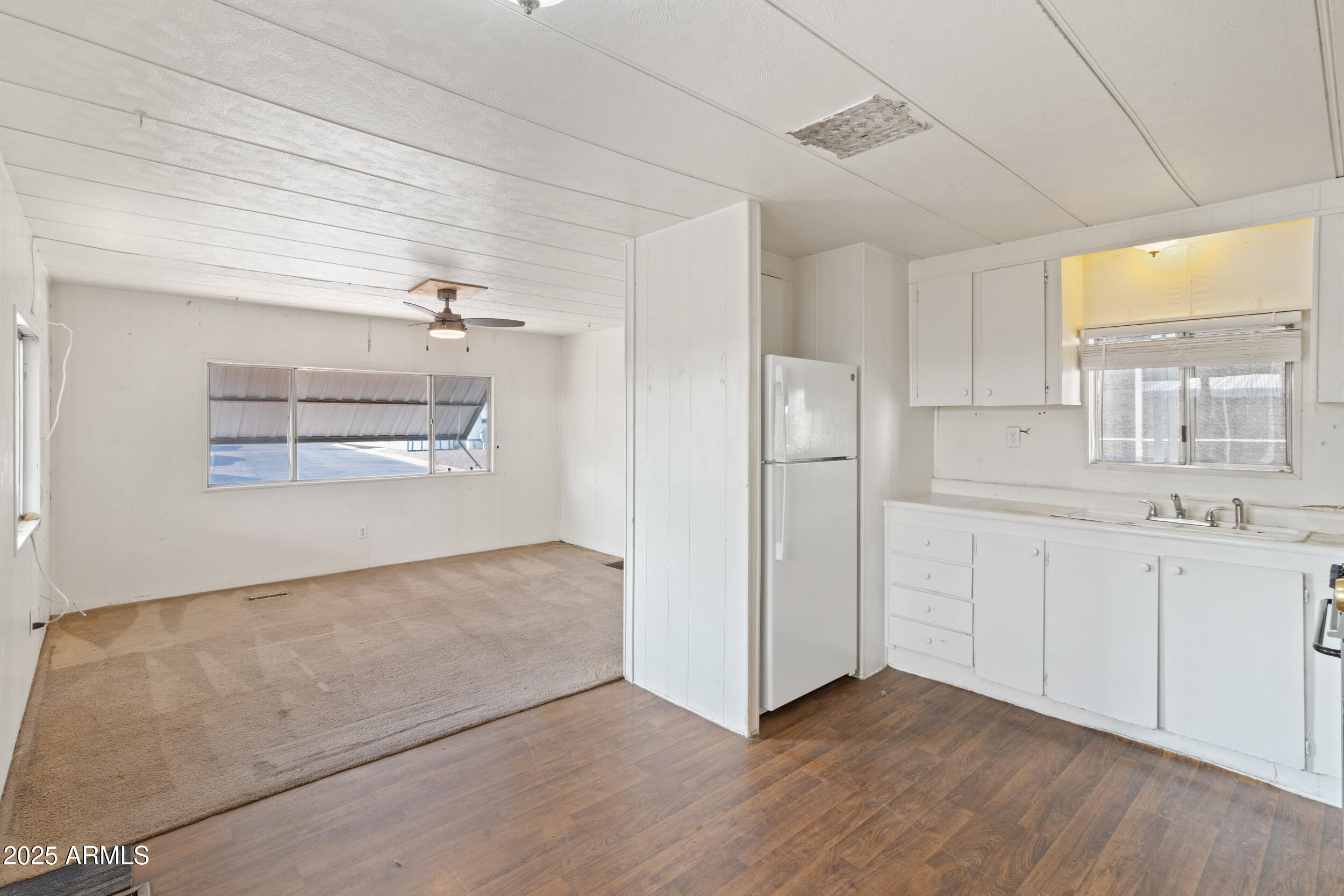 a view of kitchen with wooden floor electronic appliances and window