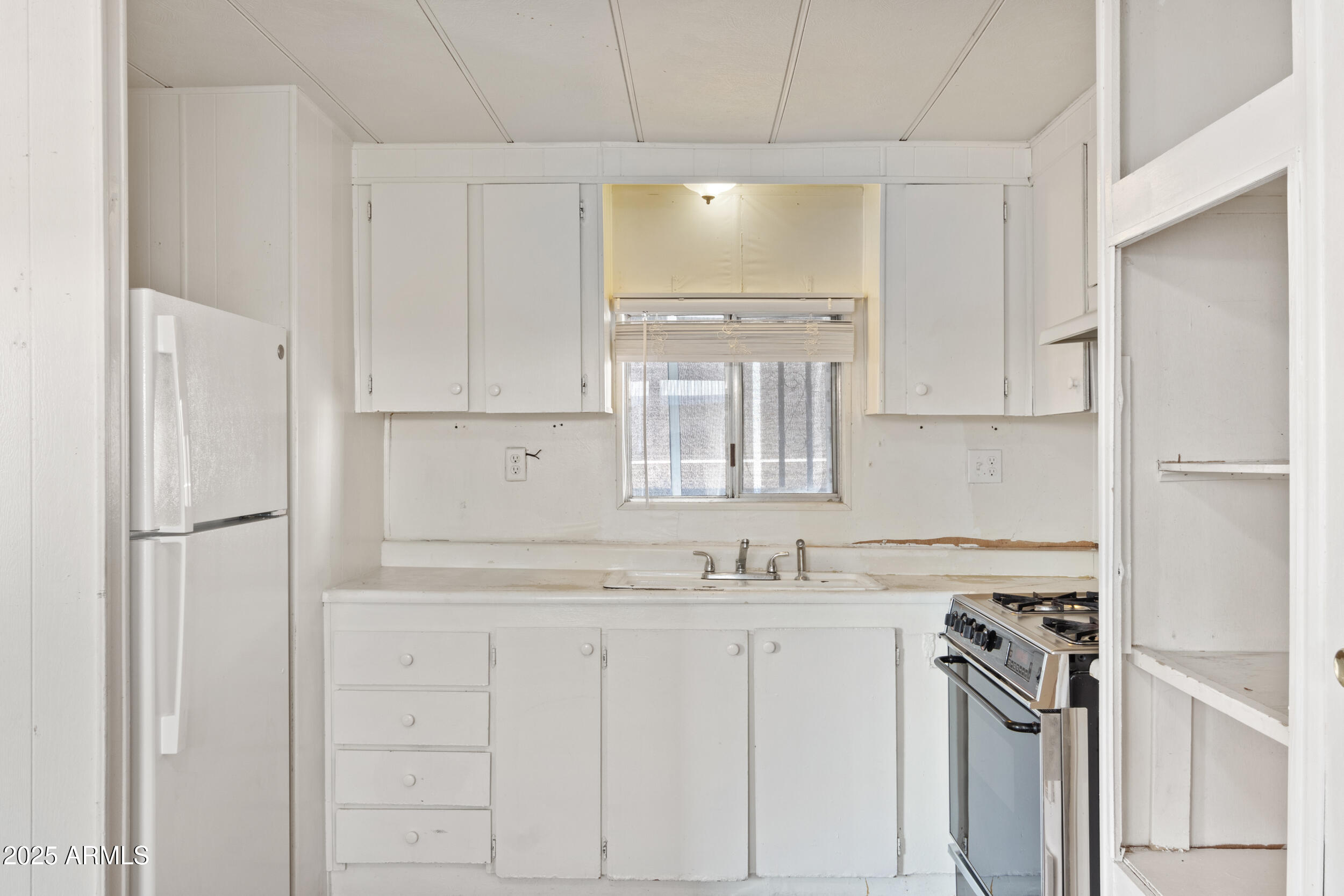 535 South Alma School Road, Unit 12 Mesa, AZ 85210 - Photo 11 of 66 a kitchen with white cabinets and white appliances