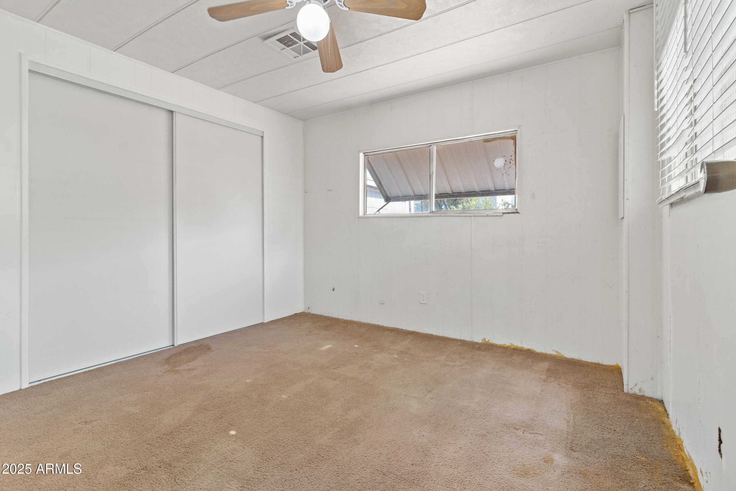 535 South Alma School Road, Unit 12 Mesa, AZ 85210 - Photo 18 of 66 an empty room with a ceiling fan and window