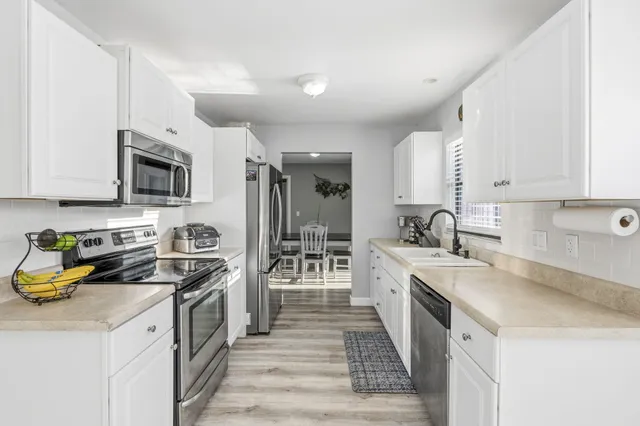 a kitchen with a sink stove top oven and refrigerator