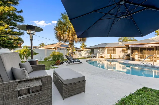 a front view of house and swimming pool with seating space