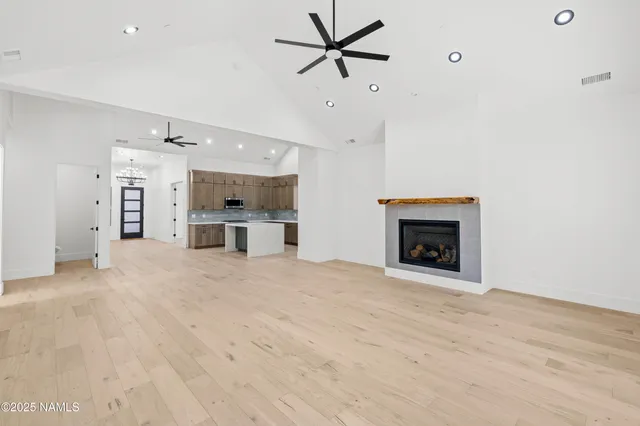 an aerial view of a residential houses with outdoor space and trees all around