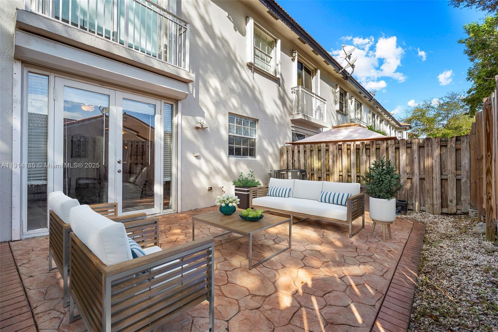 8181 Southwest 118th Court Miami, FL 33183 - Photo 27 of 33 a view of a patio with couches table and chairs with wooden floor and fence