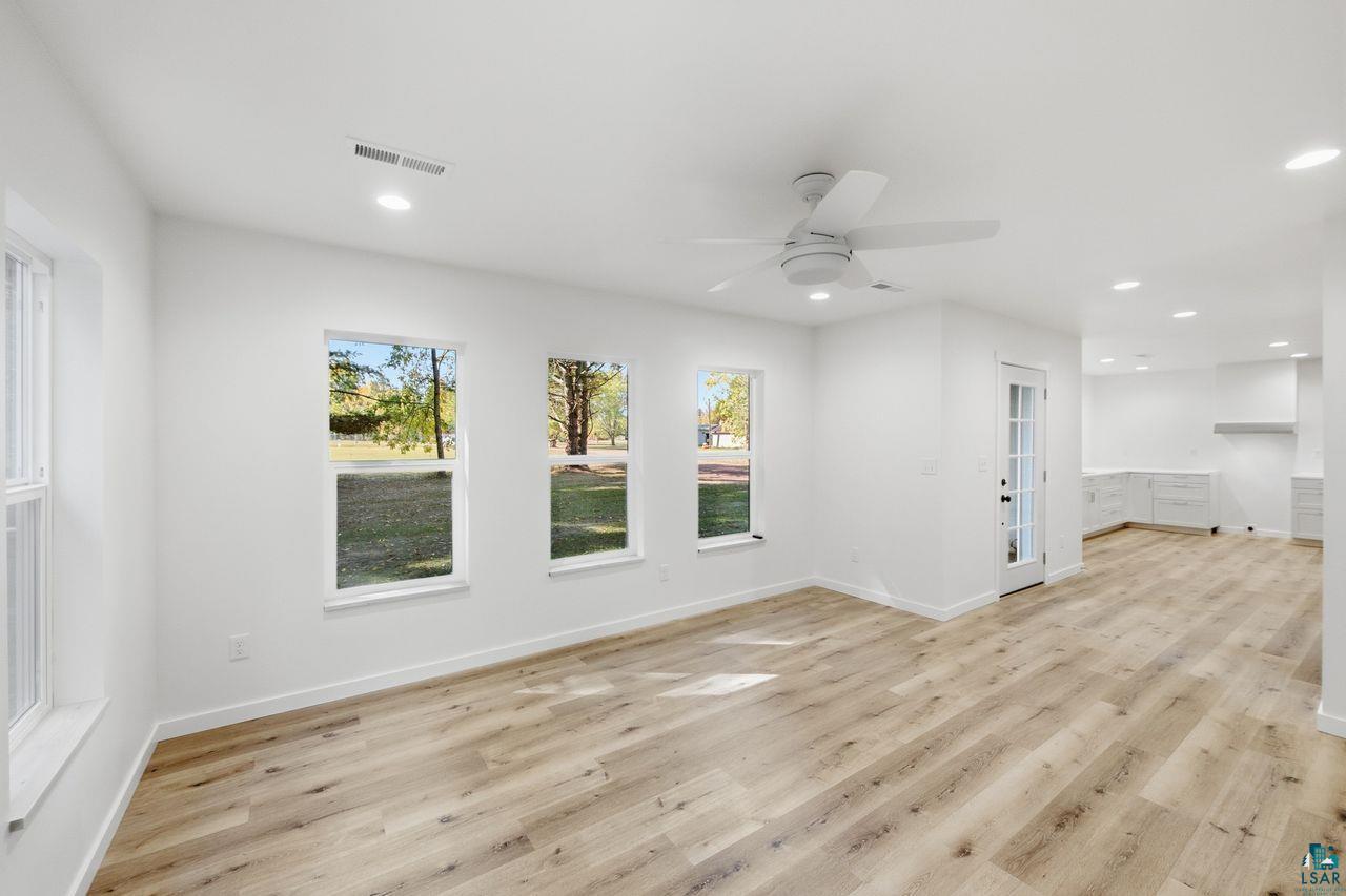65352 Adler Road Marengo, WI 54855 - Photo 8 of 24 Wood-finish flooring, multiple windows, recessed lighting, ceiling fan, and a glass-paneled door