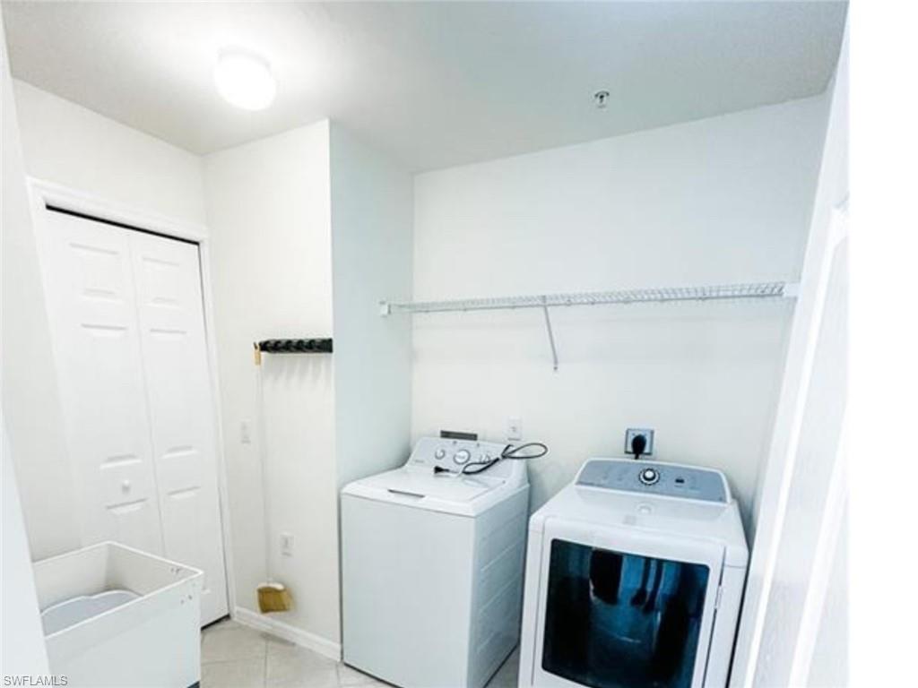 2380 Bayou Lane, Unit 7709 Naples, FL 34112 - Photo 15 of 15 Laundry area with laundry area, washing machine and dryer, and light tile patterned floors