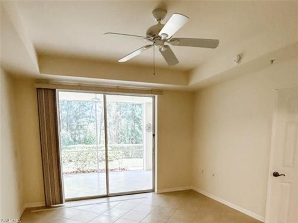 2380 Bayou Lane, Unit 7709 Naples, FL 34112 - Photo 3 of 15 Empty room with baseboards, a ceiling fan, a tray ceiling, and light tile patterned floors