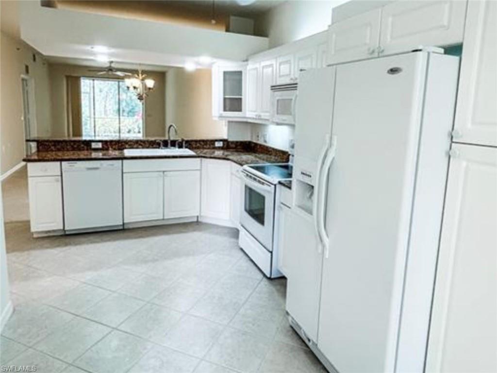 2380 Bayou Lane, Unit 7709 Naples, FL 34112 - Photo 4 of 15 Kitchen with a sink, white cabinetry, dark countertops, and white appliances