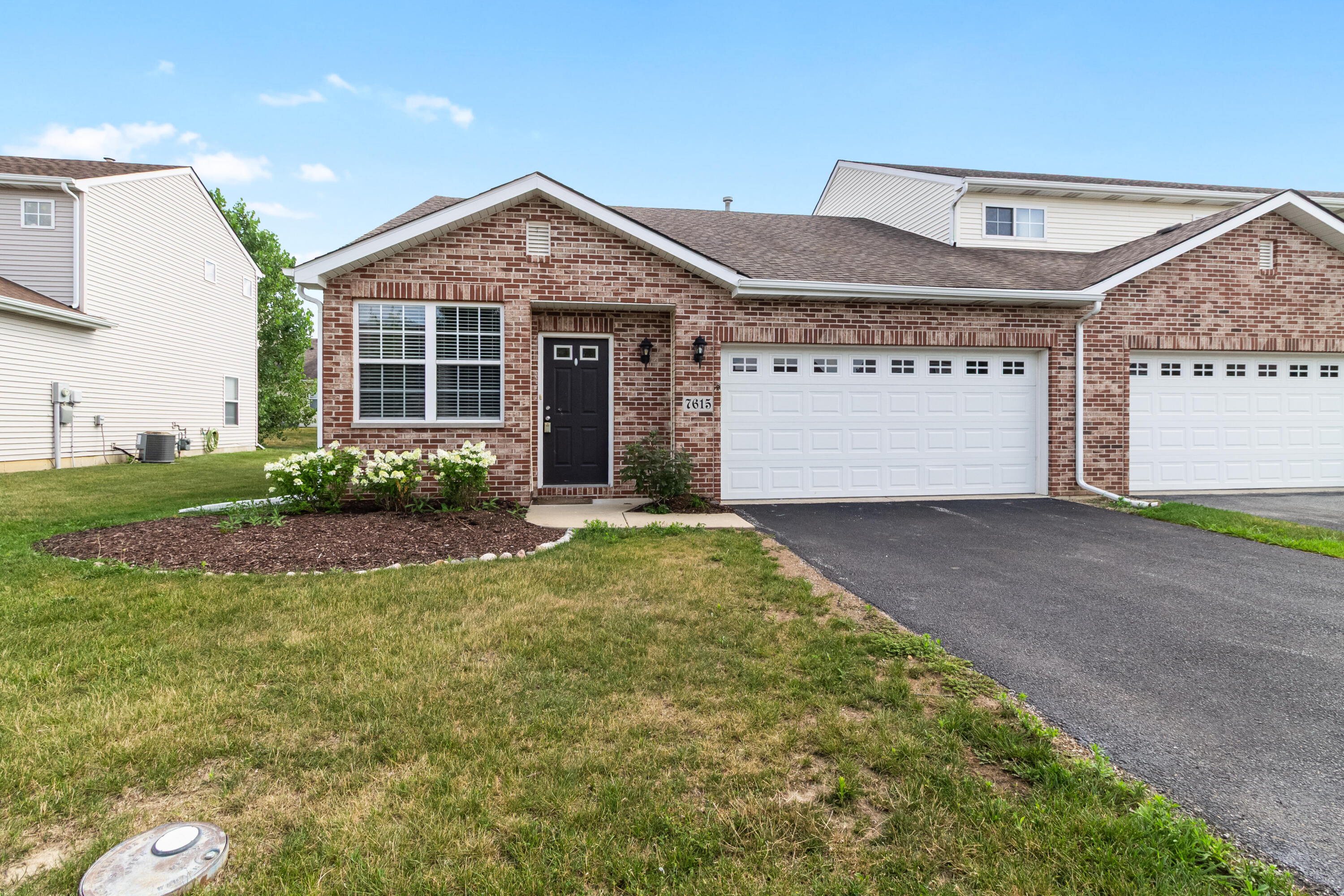 7615 111th Lane Crown Point, IN 46307 - Photo 1 of 19 a front view of a house with garden