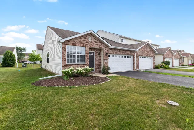 a view of a house next to a big yard and large trees